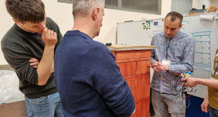 Wizyta grupy operacyjnej Systemu Nadzoru Ula Pszczelego w Łukasiewicz - Poznańskim Instytucie Technologicznym Na zdjęciu zespół projektowy z pszczelarzem przy prototypie ula.